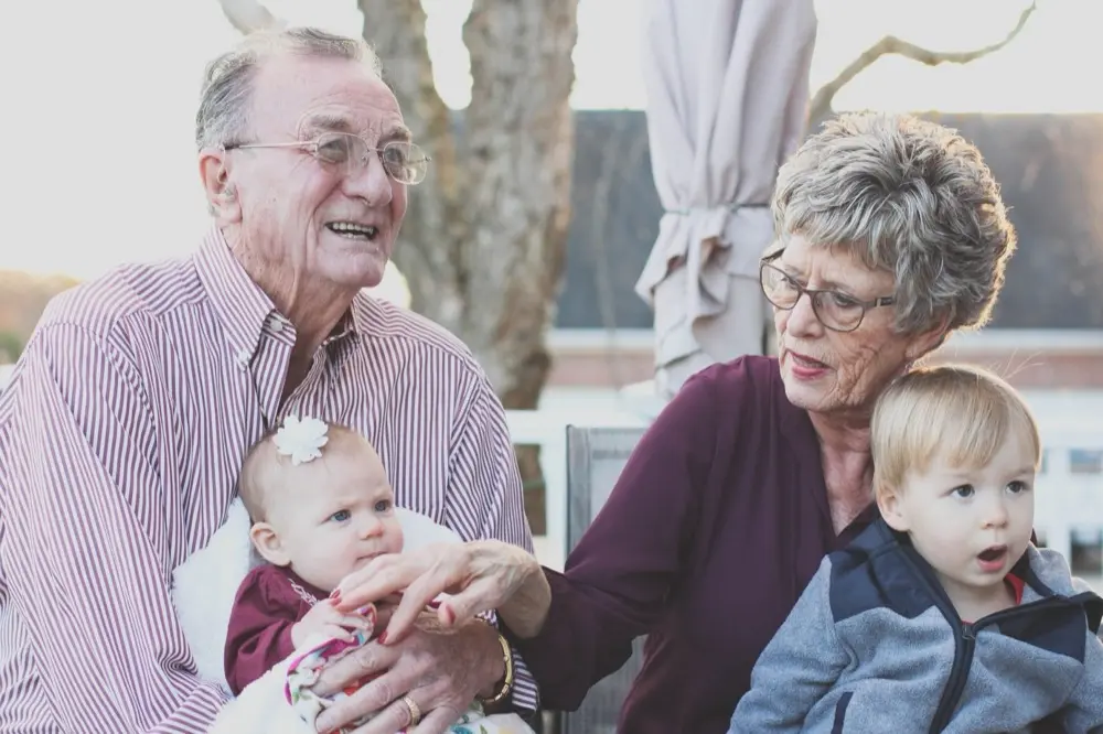 Grandfather and grandmother smiling with a baby